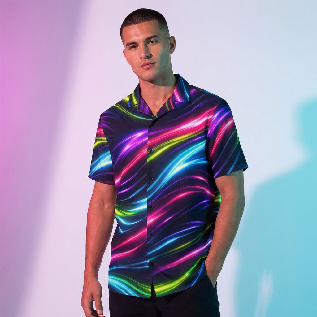 Man wearing the Neon Flow button-up shirt in a pastel studio – neon pink, blue and lime flow print on black
