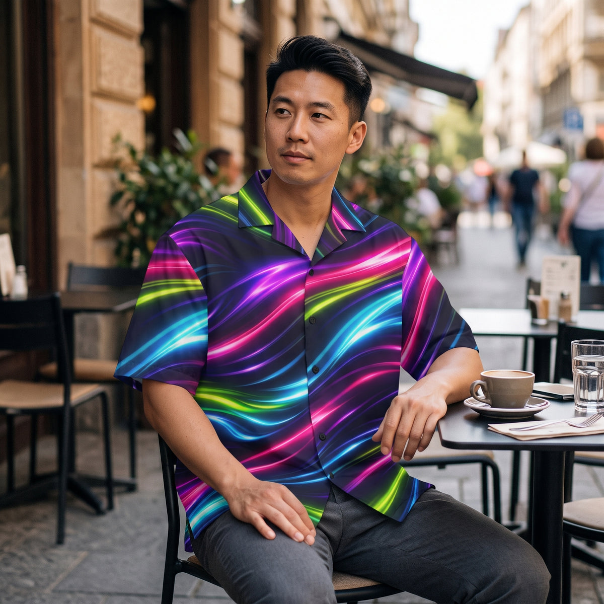 Man wearing the Neon Flow button-up shirt at an outdoor city café table