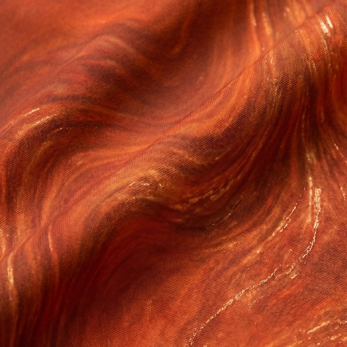 Close-up of the burnt orange and copper fluid marble print on the shirt fabric