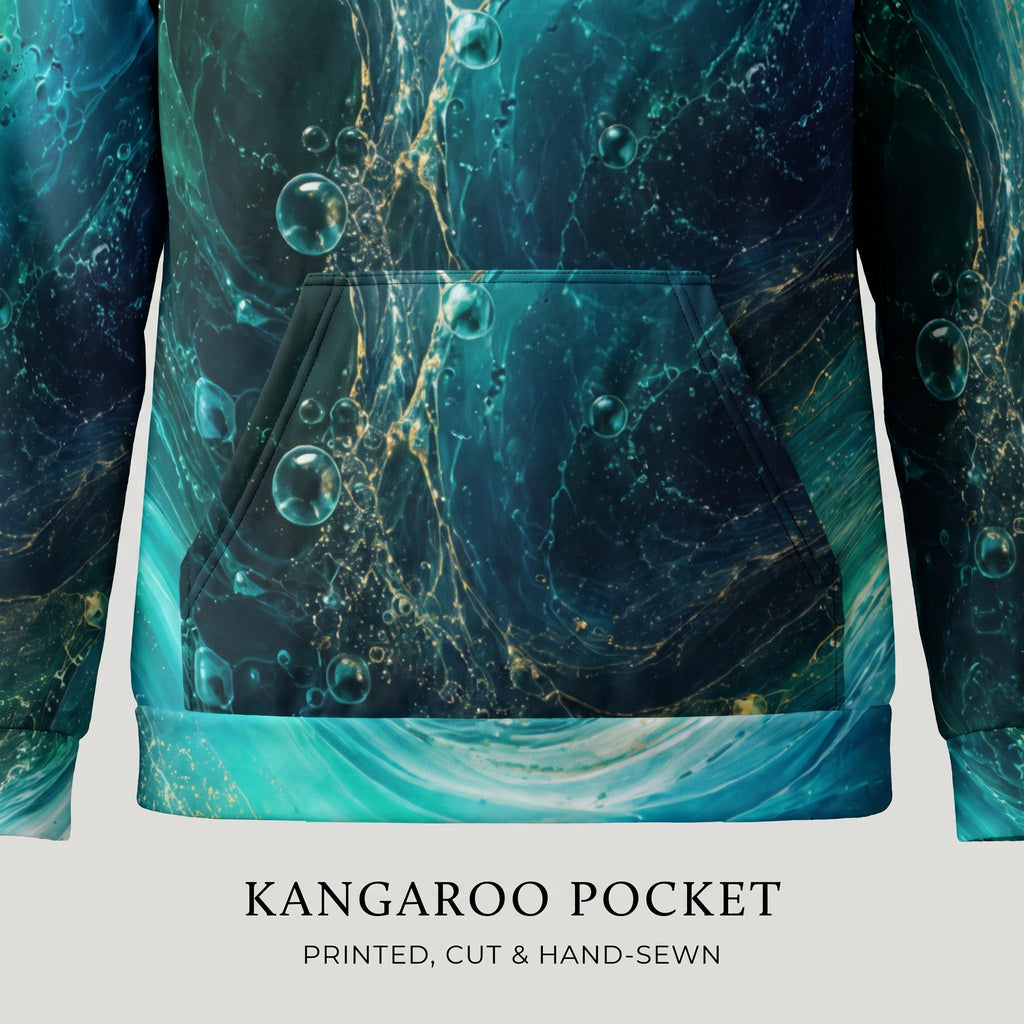 Close-up of a hoodie front showing a kangaroo pocket with an abstract teal, blue, and gold marbled print. Text below reads 'KANGAROO POCKET' and 'PRINTED, CUT & HAND-SEWN'.