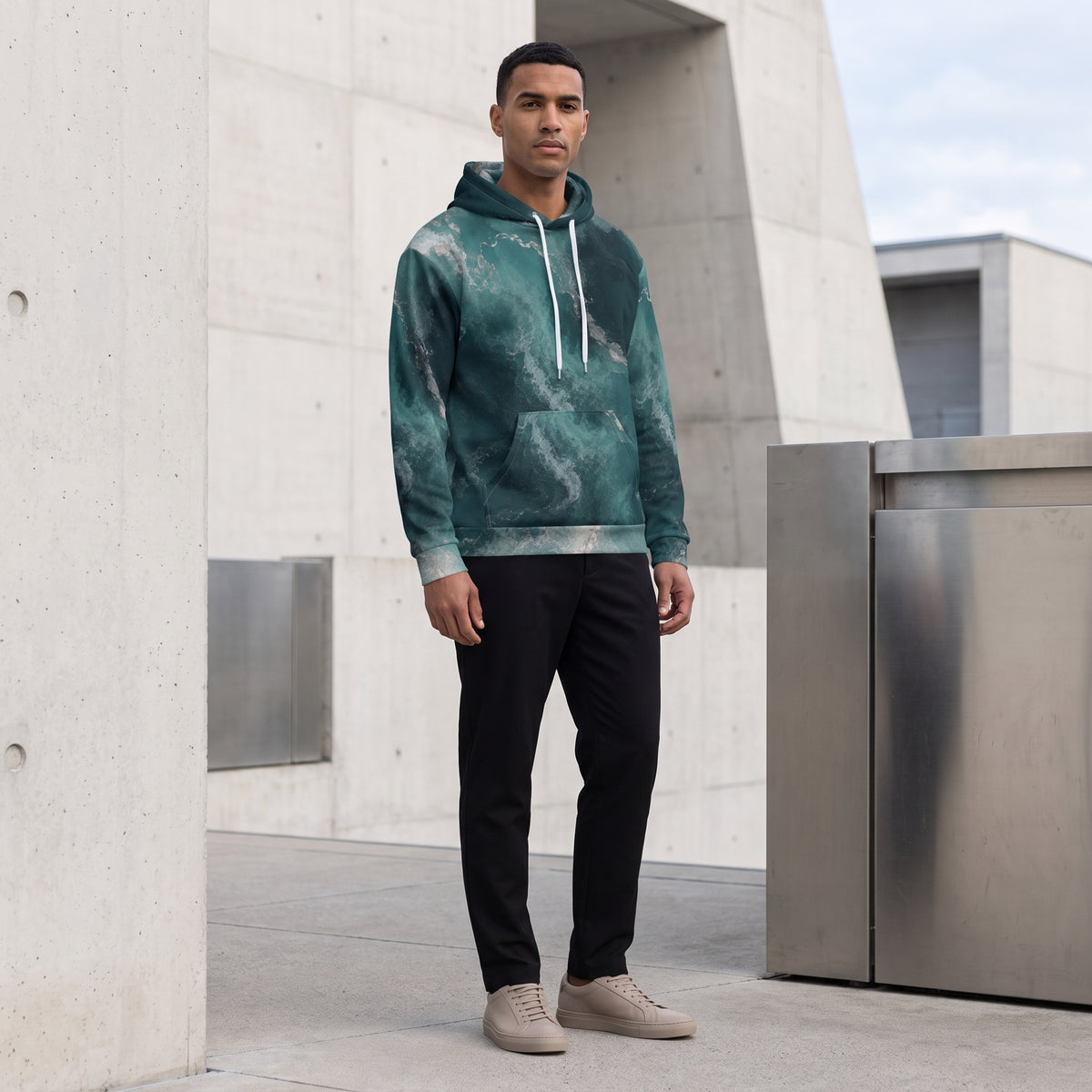 Man wearing the Abyssal Current unisex hoodie in teal and turquoise