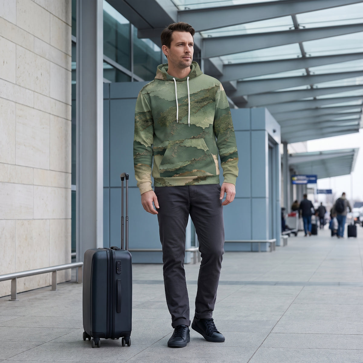 Man posing in the Verdant Terrain hoodie – sage, olive and gold abstract print