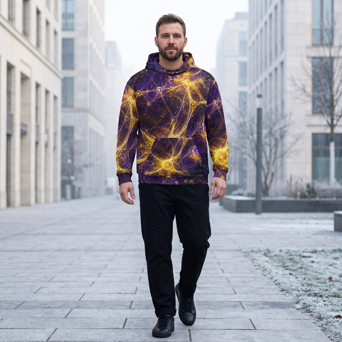 A man walking down a city street wearing a purple and yellow cosmic nebula print hoodie, black pants, and black shoes.