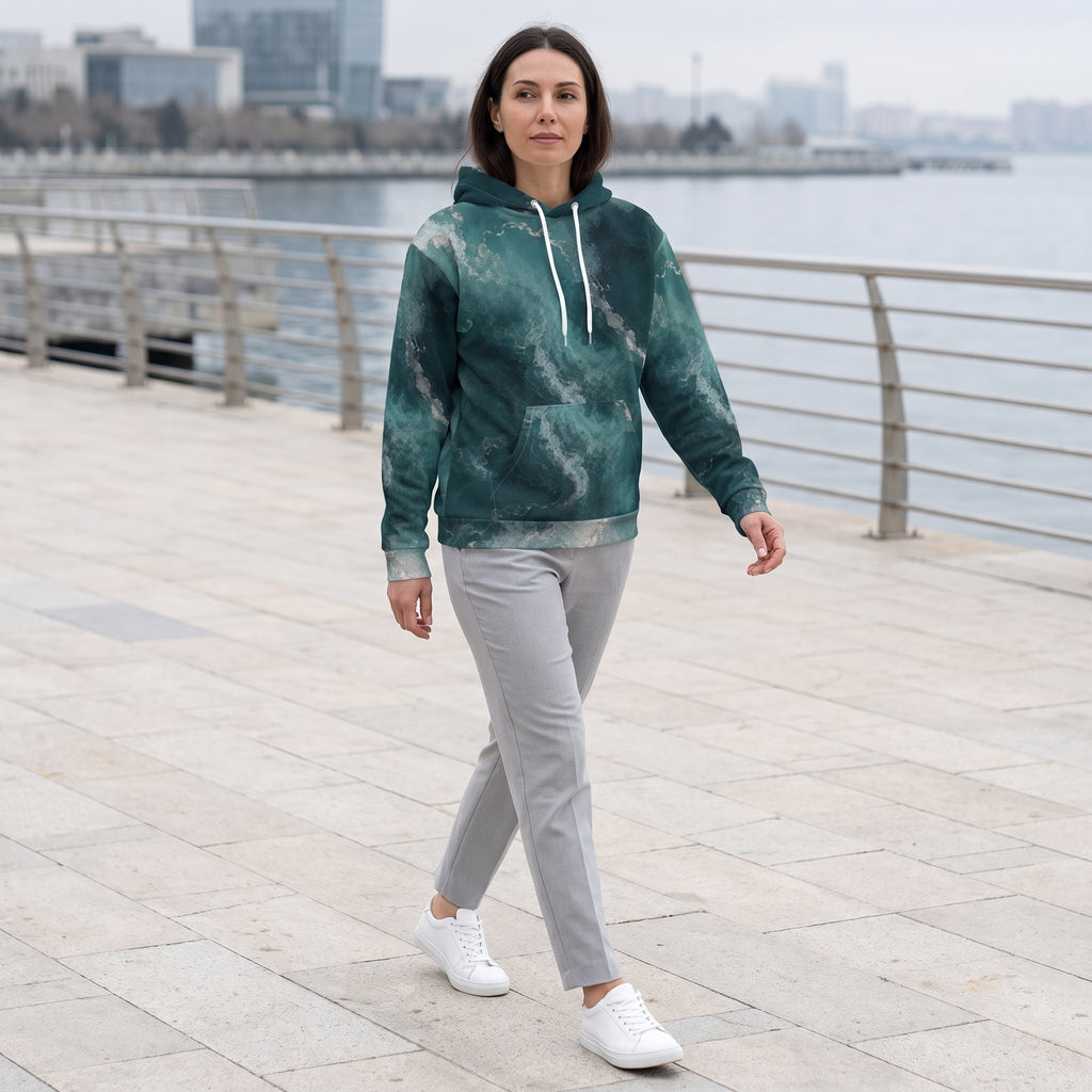 Model wearing the Abyssal Current teal marble hoodie on a promenade