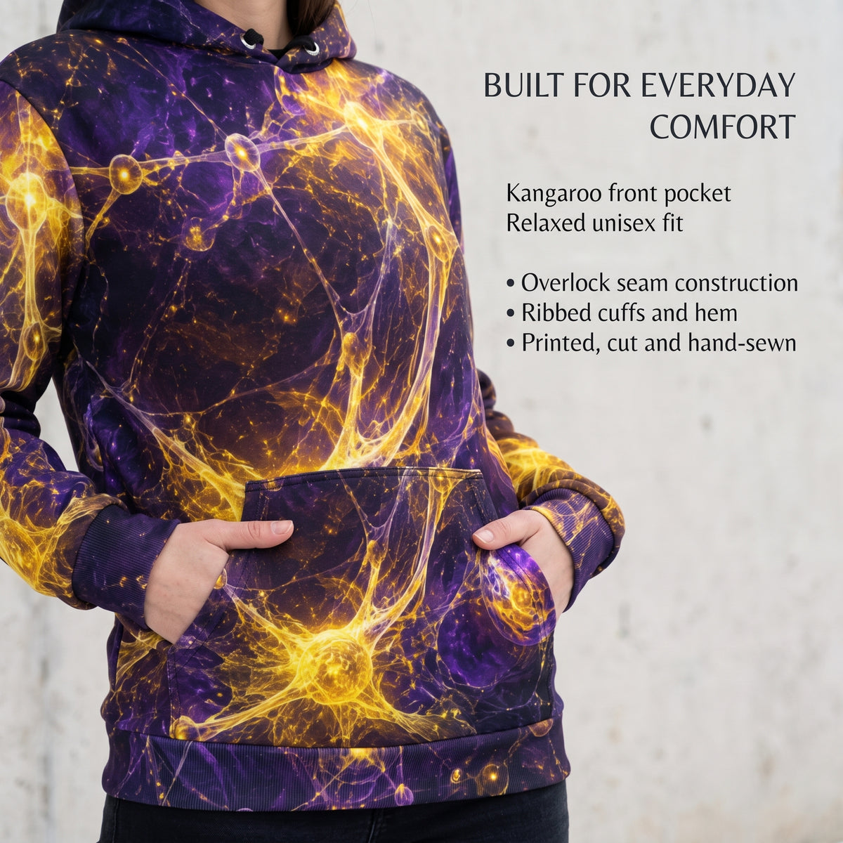 A person wearing a purple hoodie with a glowing yellow and gold neuron pattern, shown from the chest down with hands in the front pocket. Text on the right lists features like kangaroo pocket and relaxed unisex fit.