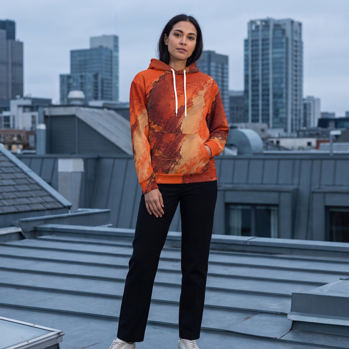 Model wearing the Ember Terrain hoodie – burnt orange, rust and brown earth-tone print