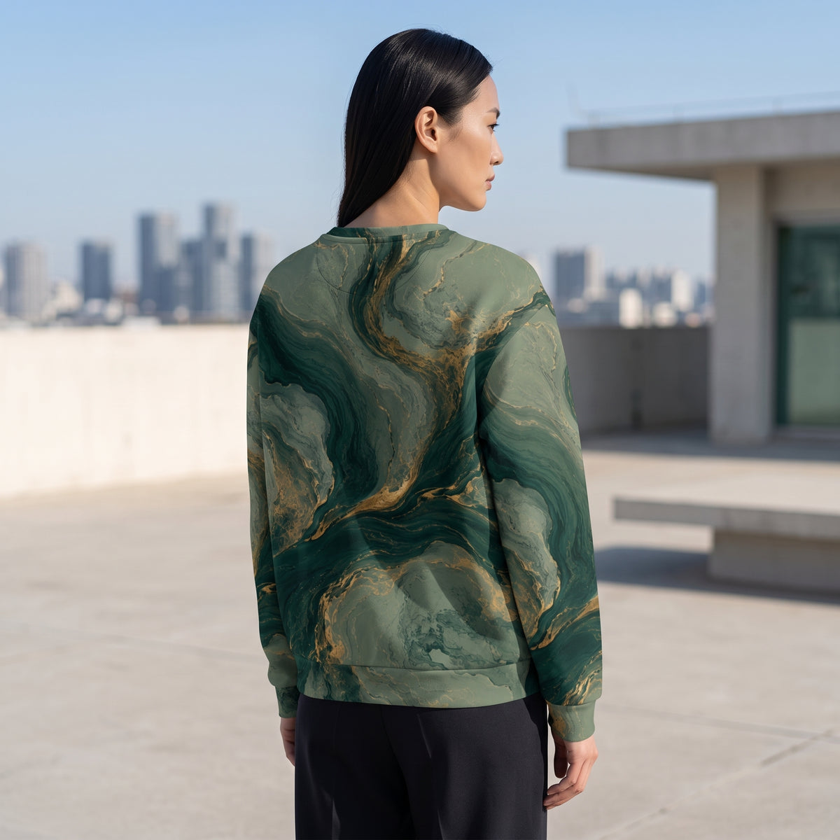 Model wearing the Emerald Current sweatshirt on a rooftop, green and gold print
