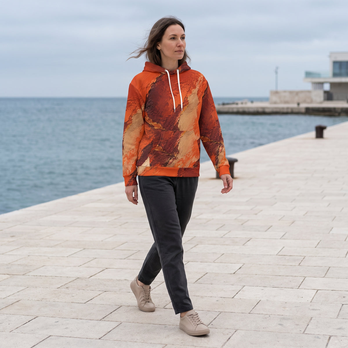 Woman walking in the Ember Terrain hoodie, burnt orange and brown print