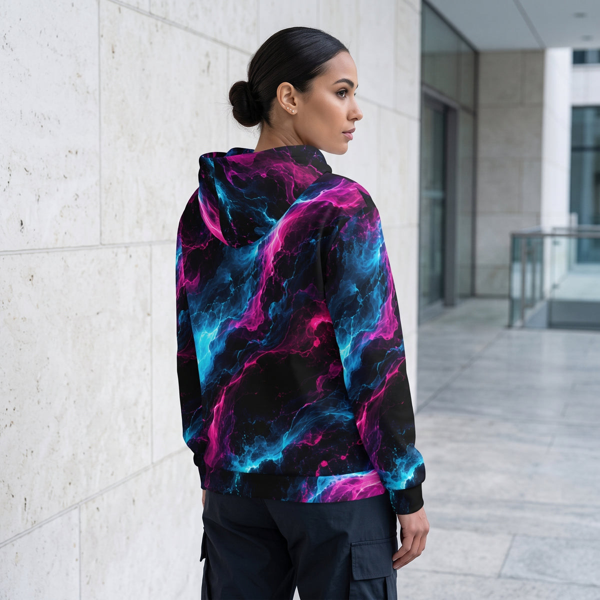 Woman wearing the Neon Vortex zip hoodie – cyan, magenta and black nebula print